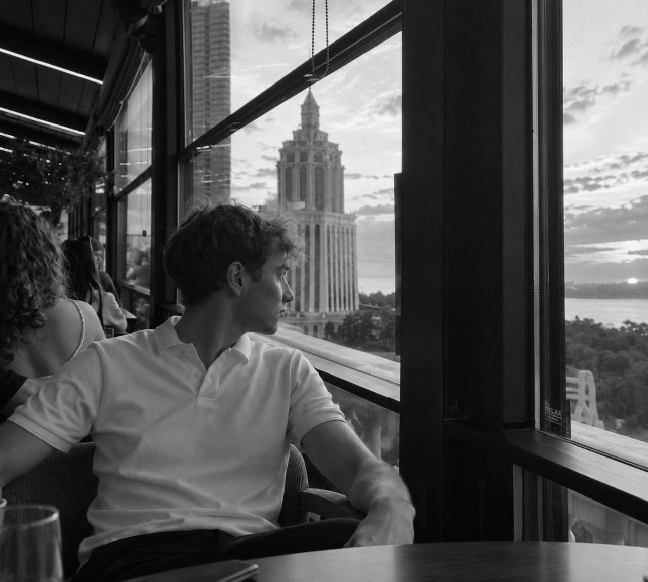 Portrait of Stepan Kolesnichenko at a window-side table overlooking the city
